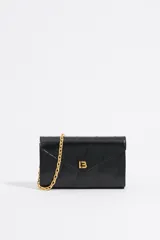 Mini bolso negro con diseño acolchado y logo dorado en el frente. Incluye correa de cadena dorada.
