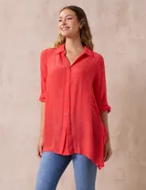 Camisa color beige claro, de corte recto y mangas 3/4 con botón para sujetar.