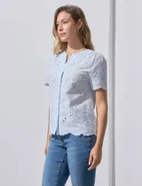 Blusa celeste de algodón con bordado broderie, cuello a la base con abertura central y botones.