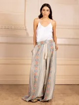 Pantalón palazzo marrón con bordados de estilo étnico en colores azul, naranja y rosa. Tiene cintura elástica con cordón ajustable y bolsillos laterales.