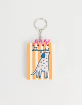 Llavero con forma de libreta con espiral, diseño de perro con manchas en relieve y fondo a rayas verticales.