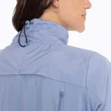 Buzo celeste con cuello alto, cierre de cremallera, elástico ajustable en la cintura y bolsillos laterales.