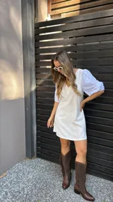 Vestido corto color crudo, con escote en V y mangas 3/4 abullonadas con detalles de calado.