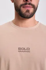 Remera manga corta color beige, corte oversize, con estampa frontal "BOLD GRAPHIC" en marrón.