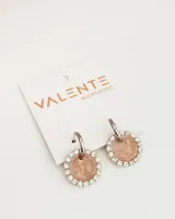 Aros colgantes con forma circular, con centro color rosa marmolado y borde con strass plateados.