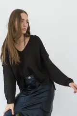 Sweater negro de tejido de punto con escote en V y mangas largas.