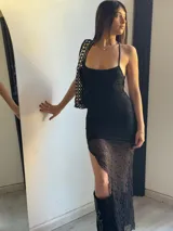Vestido midi negro de encaje con breteles finos y abertura lateral.