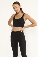 Top deportivo negro con breteles finos cruzados en la espalda y almohadillas removibles.