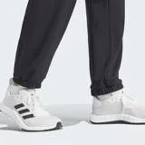 Pantalón deportivo Adidas negro, de corte holgado, confeccionado en felpa con tecnología AEROREADY. Presenta cintura elástica con cordón ajustable y puños elásticos en los tobillos.