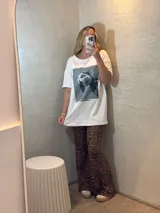 Conjunto de remera color crema de mangas cortas y pantalón acampanado con estampado animal print de leopardo.