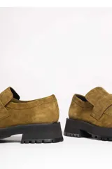 Mocasín de gamuza color verde oliva, con tira superior y suela track gruesa y negra.