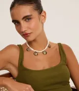 Collar maxi con cadena múltiple encerada con colgantes redondos con textura de ondas. Cierre por tornillo y baño anti gold.