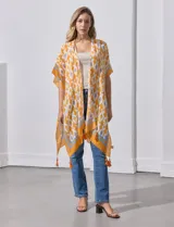 Kimono tejido color naranja con estampado geométrico en blanco y celeste, y terminación con borlas.