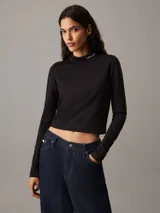 Top negro de manga larga con cuello alto y logo de Calvin Klein bordado en el cuello.