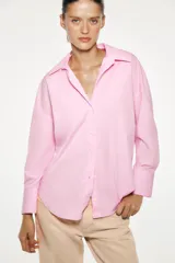Camisa amarilla de popelina de algodón, con cuello solapa, escote en pico, manga larga con puños y cierre frontal con botones.