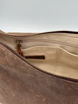 Cartera bandolera marrón de cuero con correa ajustable.