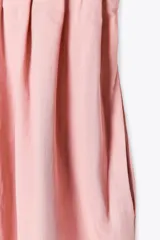 Vestido midi color marrón confeccionado en hilatura con mezcla de algodón y lino. Tiene cuello redondo, manga corta caída y detalle de pliegues en la cintura. Cierre en la espalda con abertura y botón.