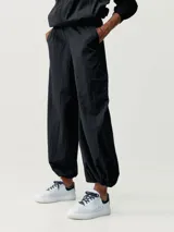 Pantalón parachute negro de tejido técnico Wind_S, con bolsillos laterales, cintura ajustable y tobillos ajustables. Diseño holgado.