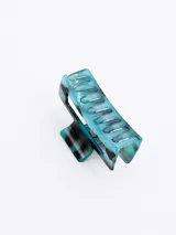 Broche para el pelo tipo pinza, color celeste con manchas marrones.