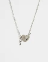 Cadena corta plateada con dije de corazón y llave. El corazón tiene un cierre tipo toggle.