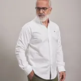 Camisa blanca tipo oxford, con botones frontales y ajuste regular.