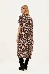 Vestido midi estampado animal print, con cuello en V y manga corta ancha. Presenta un calce holgado y bolsillos laterales.