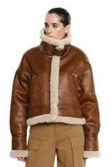 Chaqueta marrón de cuero sintético con interior de piel sintética color crema, cuello alto con hebilla ajustable y bolsillos laterales.