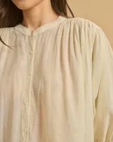Camisa color crema, de corte holgado, con cuello mao y mangas 3/4 abullonadas.