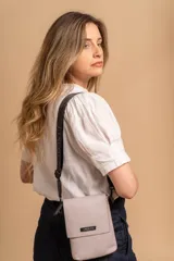 Bandolera tipo phone bag pequeña, color marrón claro, con correa de galón regulable. Tiene un compartimento principal y un bolsillo adicional con tapa.