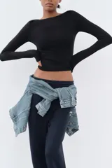 Camiseta negra de algodón con cuello barco y mangas largas.