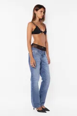 Pantalón denim azul de tiro bajo y pierna angosta. Cierre metálico con botón personalizado, cinco presillas, plastisol de marca en espalda y bolsillos laterales con relojero y remaches. Lavado azul con bigotes láser artesanales.