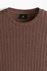 Remera marrón de punto calado suave, con cuello redondo y corte estándar.
