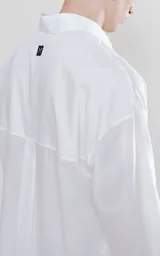 Camisa manga larga blanca de calce oversize confeccionada en textil fresco y liviano, con bolsillo ojal en delantero y cartera escondida.