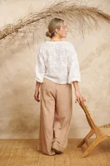 Camisa blanca con bordado de crochet, escote en V y mangas largas.