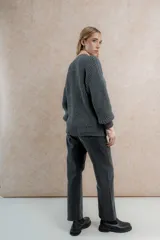 Saco de lana color verde oliva, con silueta oversize, mangas balloon, punto perlado y cuello en V.