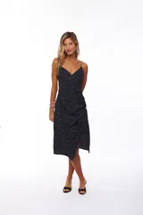 Vestido midi negro con estampado de lunares blancos, breteles finos, escote en V y falda con abertura lateral.