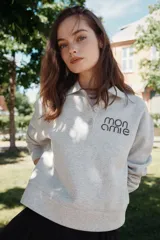 Remera polo gris de corte holgado en tejido felpa liviana con cuello y tapeta de botones. Modelo de manga larga con hombros caídos y ribete acanalado en puños y bajo.