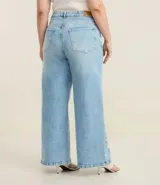 Pantalón de jean de tiro alto, color celeste claro con efecto degradado (más claro en el centro de los muslos). Corte wide leg, ancho desde la cadera hasta el tobillo.