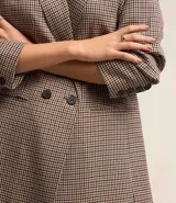 Blazer largo de poliéster con viscosa y elastano, con estampado de cuadros, cuello solapa, manga larga y cierre frontal con un botón.