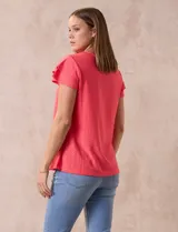 Blusa blanca de tejido pointelle con manga corta con volados y cuello redondo.