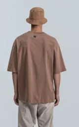 Remera de manga corta, corte crop y calce oversize, color marrón claro (cañamo). Presenta cuello redondo rib al tono y doble costura.