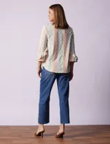 Blusa estampada con rayas verticales en tonos pastel y flores blancas. Tiene escote en V y mangas 3/4 con volados.
