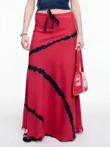 Falda larga roja con lazo ajustable en la cintura y estampado tie-dye negro.