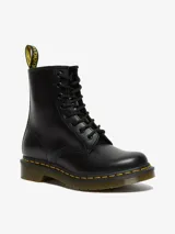 Bota de cuero negro Dr. Martens modelo 1460 W, de caña media con 8 ojales, costuras amarillas en la suela y tira con logo en el talón.