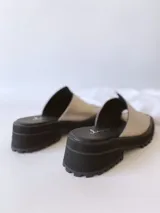 Sandalias doradas con tira para el dedo y suela track negra.