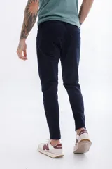 Pantalón de jean azul oscuro, corte skinny, con bolsillos delanteros y traseros.