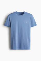 Remera deportiva azul de manga corta con cuello redondo, sección de malla en laterales y espalda, diseño reflectante en el pecho y atrás, y bajo recto. Corte musculoso con silueta entallada que realza el torso.