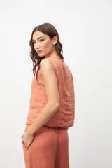 Chaleco color salmón con botones frontales y sin mangas.