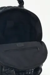 Mochila negra confeccionada en matelassé, con gran bolsillo frontal con cierre, bolsillos laterales y bolsillo interno porta notebook.
