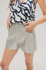 Short de cuerina color rojo, con bolsillos delanteros y traseros, y cierre frontal con botón metálico.